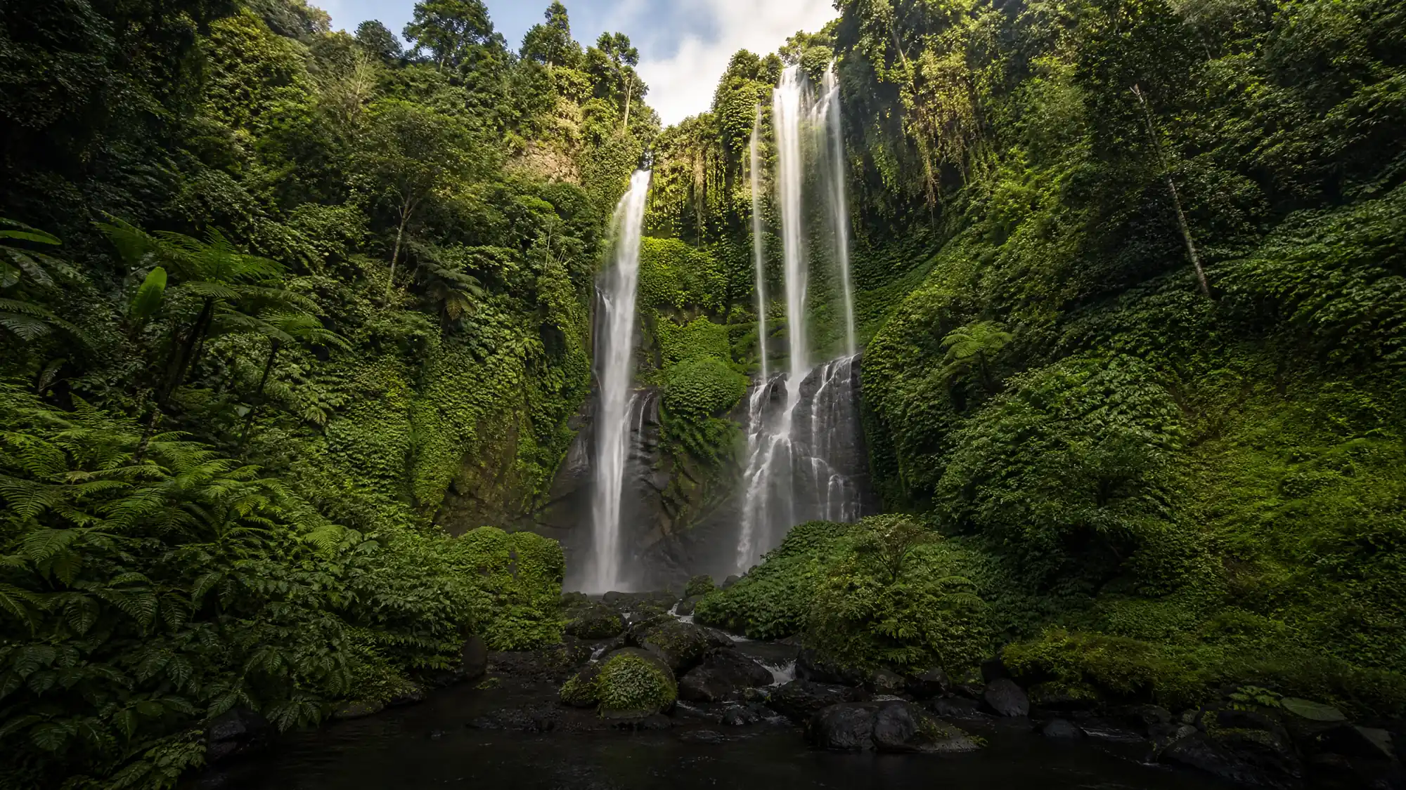 Der Sekumpul-Wasserfall besteht aus sechs bis sieben Kaskaden, die 80 Meter in ein Dschungeltal stürzen. Steigen Sie über steile Betonstufen hinunter, um den Fuß zu erreichen.