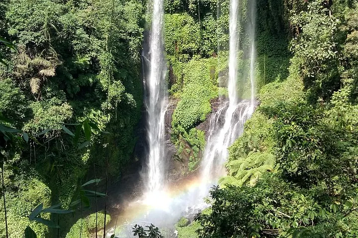 Sonnenlicht fängt einen Regenbogen am Fuß des majestätischen Sekumpul-Wasserfalls ein.